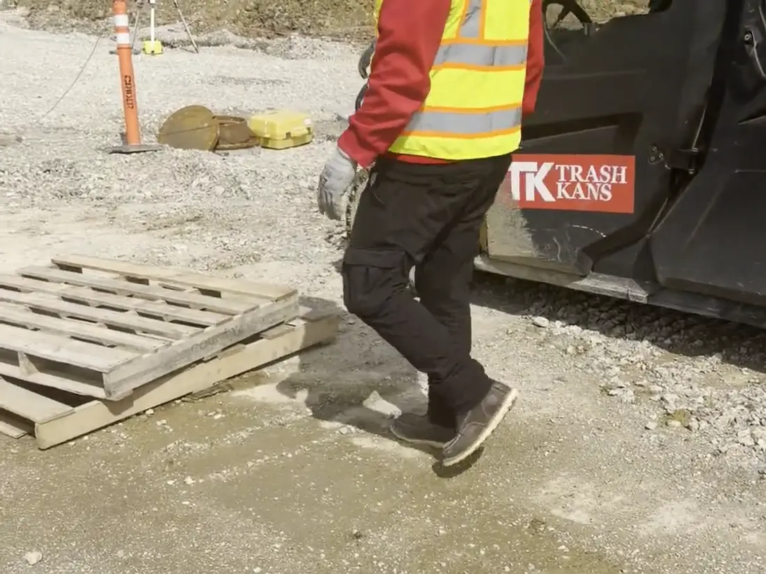 A crew carrying material past the site vehicle on an active build.