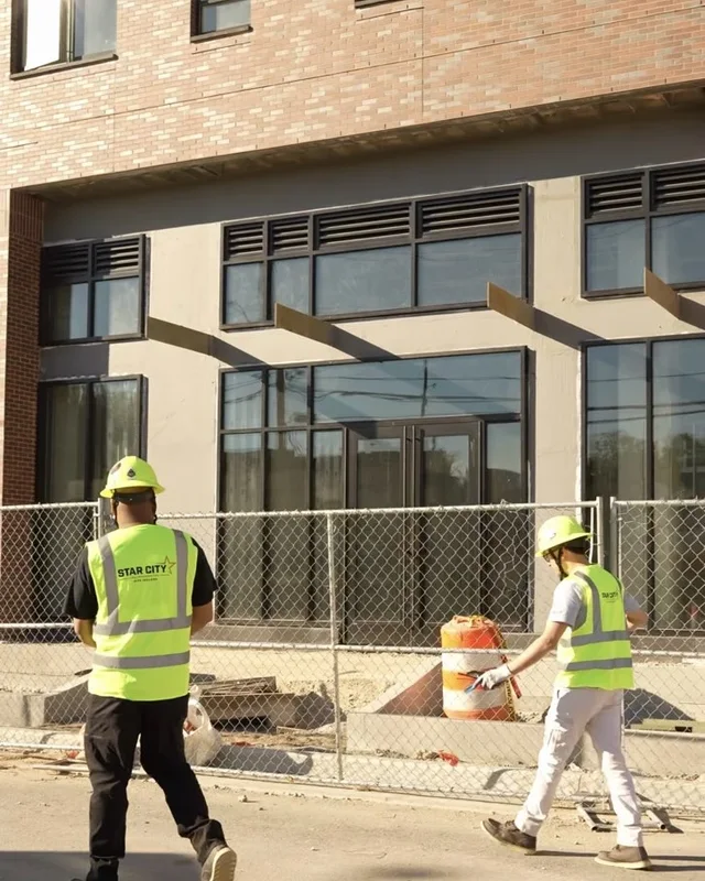 Star City Environmental crew members collecting debris outside a building under construction during job site cleanup in Lafayette, Indiana.